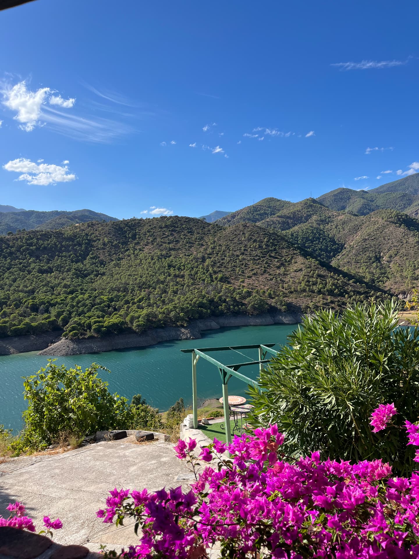 Lake Istán framed by mountains and flowering bougainvillea